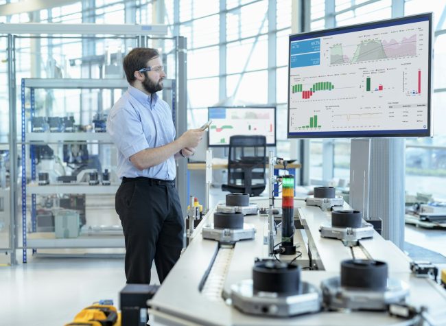 Engineer testing a robotic production simulator in robotics research facility